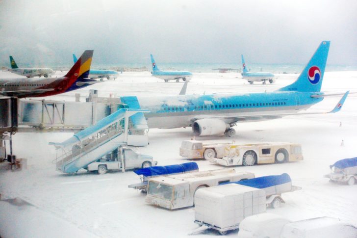 Planes are seen on the snow covered landing strip at Jeju International Airport on Jeju island