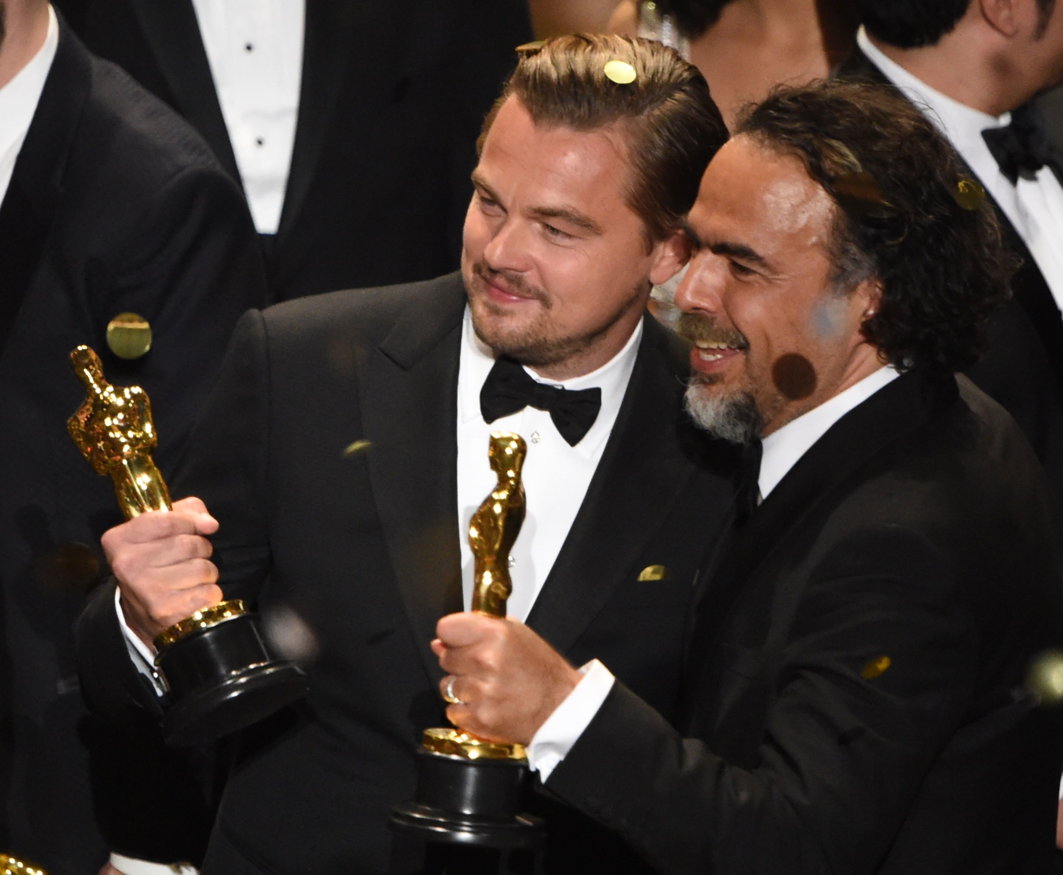 Actor Leonardo DiCaprio (L) and Director Alejandro Gonzalez Inarritu celebrate their awards on stage at the 88th Oscars on February 28, 2016 in Hollywood, California. AFP PHOTO / MARK RALSTON