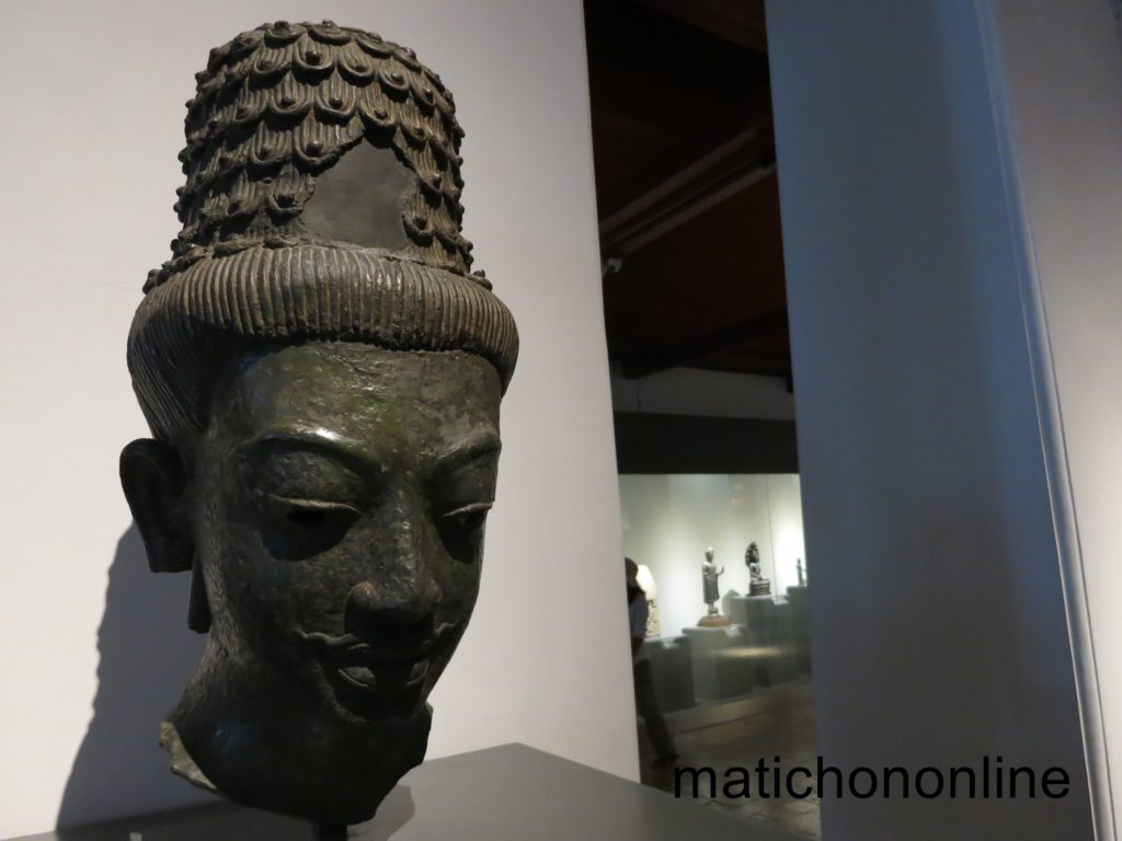 เศียรพระโพธิสัตว์ หล่อด้วยสำริด (สัญลักษณ์ที่ผมหายไป) เกล้าผมทรงชฎามงกุฎ มีพระมัสสุ (หนวด) อายุราว พ.ศ. 1200 ฝีมือช่างเขมรแบบไพรกเม็ง (จัดอยู่ในกลุ่ม “ประติมากรรมแบบประโคนชัย”) พบที่บ้านโตนด อ. โนนสูง จ. นครราชสีมา (จัดแสดงในพระที่นั่งศิวโมกขพิมาน พิพิธภัณฑสถานแห่งชาติ พระนคร)