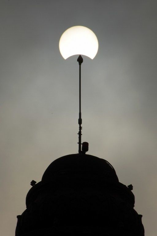 This picture shows the moon passing in front of the sun during a partial solar eclipse in Phnom Penh on March 9, 2016. A total solar eclipse swept across the vast Indonesian archipelago on March 9, witnessed by tens of thousands of sky gazers and marked by parties, Muslim prayers and tribal rituals. Partial eclipses were also visible over other parts of Asia and Australia. / AFP / TANG CHHIN SOTHY