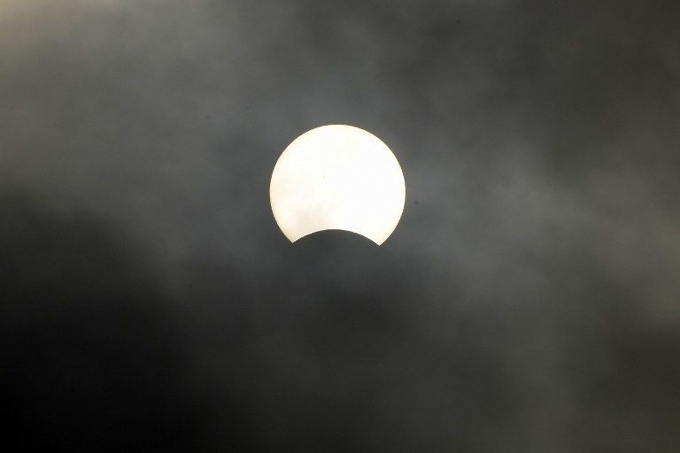 This picture shows the moon passing in front of the sun during a partial solar eclipse in Phnom Penh on March 9, 2016. A total solar eclipse swept across the vast Indonesian archipelago on March 9, witnessed by tens of thousands of sky gazers and marked by parties, Muslim prayers and tribal rituals. Partial eclipses were also visible over other parts of Asia and Australia. / AFP / TANG CHHIN SOTHY
