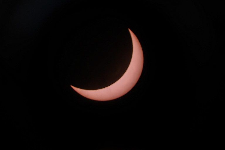This picture taken through a telescope shows a partial solar esclipse at the National Planetarium in Kuala Lumpur on March 9, 2016. A total solar eclipse swept across the vast Indonesian archipelago on March 9, witnessed by tens of thousands of sky gazers and marked by parties, Muslim prayers and tribal rituals. Partial eclipses were also visible over other parts of Asia and Australia. / AFP / MOHD RASFAN