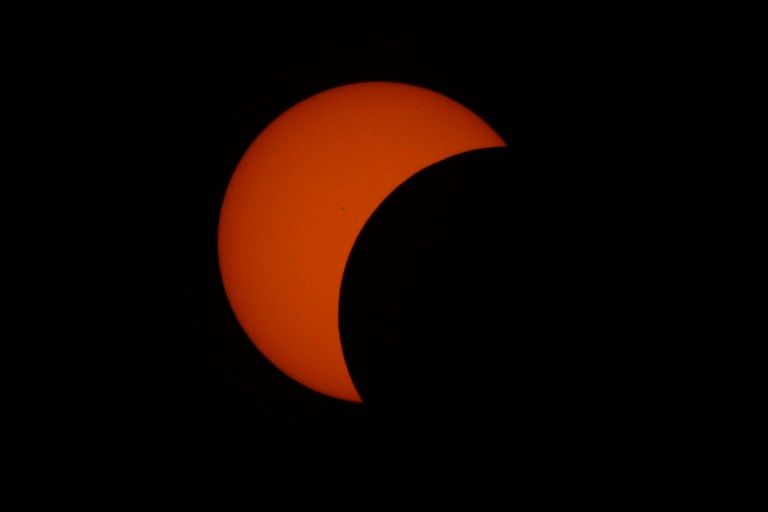 This picture shows the moon passing in front of the sun during a partial solar eclipse in Manila on March 9, 2016. A total solar eclipse swept across the vast Indonesian archipelago on March 9, witnessed by tens of thousands of sky gazers and marked by parties, Muslim prayers and tribal rituals. Partial eclipses were also visible over other parts of Asia and Australia. / AFP / TED ALJIBE