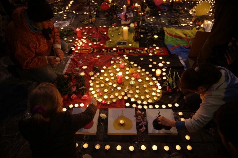 People light candles in tribute to victims at a makeshift memorial in front of the stock exchange at the Place de la Bourse (Beursplein) in Brussels on March 22, 2016, following triple bomb attacks in the Belgian capital that killed about 35 people and left more than 200 people wounded. A series of explosions claimed by the Islamic State group ripped through Brussels airport and a metro train on March 22, killing around 35 people in the latest attacks to bring bloody carnage to the heart of Europe. AFP PHOTO / KENZO TRIBOUILLARD / AFP / KENZO TRIBOUILLARD