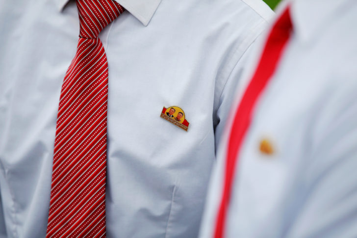 Schoolchildren wear badges with pictures of former North Korean leaders Kim Il Sung and Kim Jong Il near April 25 House of Culture, the venue of Workers' Party of Korea (WPK) congress in Pyongyang