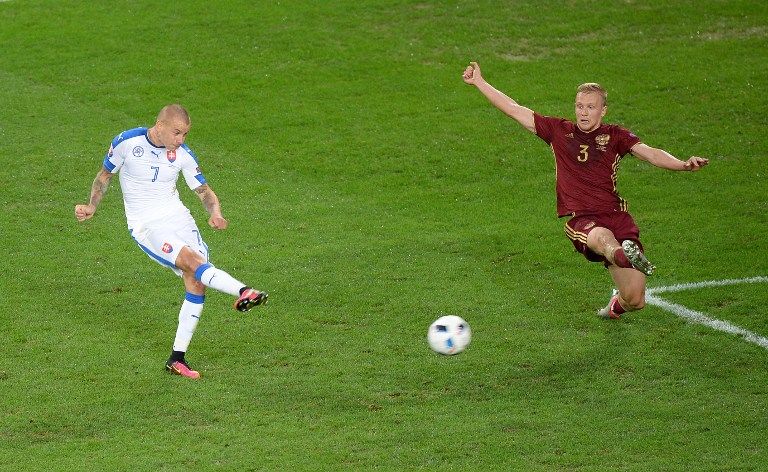 Slovakia's midfielder Vladimir Weiss (L) shoots to score during the Euro 2016 group B football match between Russia and Slovakia at the Pierre-Mauroy Stadium in Villeneuve-d'Ascq, near Lille, on June 15, 2016. / AFP PHOTO / DENIS CHARLET