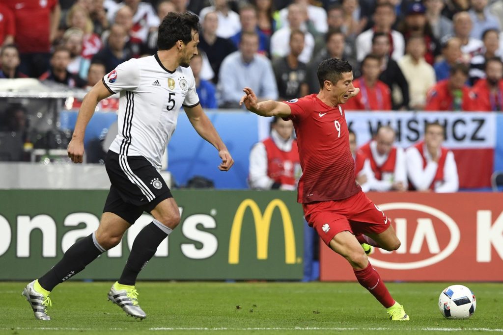 Poland's forward Robert Lewandowski (R) attempts a shot past Germany's defender Mats Hummels during the Euro 2016 group C football match between Germany and Poland at the Stade de France stadium in Saint-Denis near Paris on June 16, 2016. / AFP PHOTO / MIGUEL MEDINA