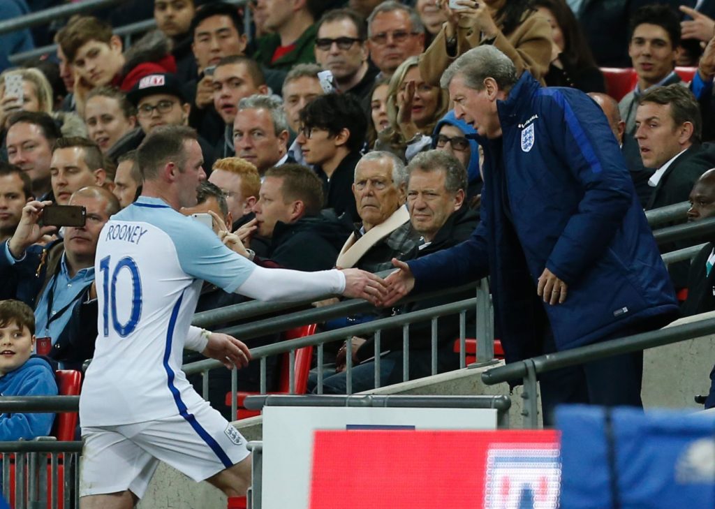 England's striker Wayne Rooney (L) shakes hands with England's manager Roy Hodgson after being substituted during the friendly football match between England and Portugal at Wembley stadium in London on June 2, 2016. / AFP PHOTO / Ian Kington