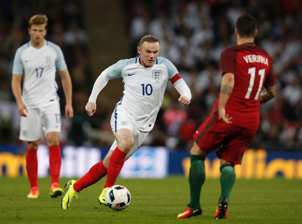 England's striker Wayne Rooney (C) vies with Portugal's Vieirinha during the friendly football match between England and Portugal at Wembley stadium in London on June 2, 2016. / AFP PHOTO / ADRIAN DENNIS