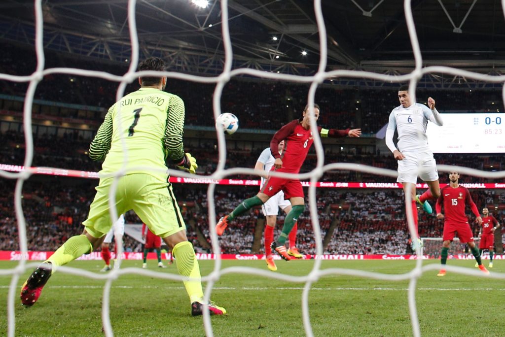 England's defender Chris Smalling (R) heads the ball to score during the friendly football match between England and Portugal at Wembley stadium in London on June 2, 2016. / AFP PHOTO / ADRIAN DENNIS