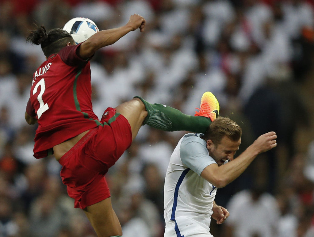 TOPSHOT - Portugal's defender Bruno Alves (L) fouls England's striker Harry Kane to receive a red card during the friendly football match between England and Portugal at Wembley stadium in London on June 2, 2016. / AFP PHOTO / ADRIAN DENNIS