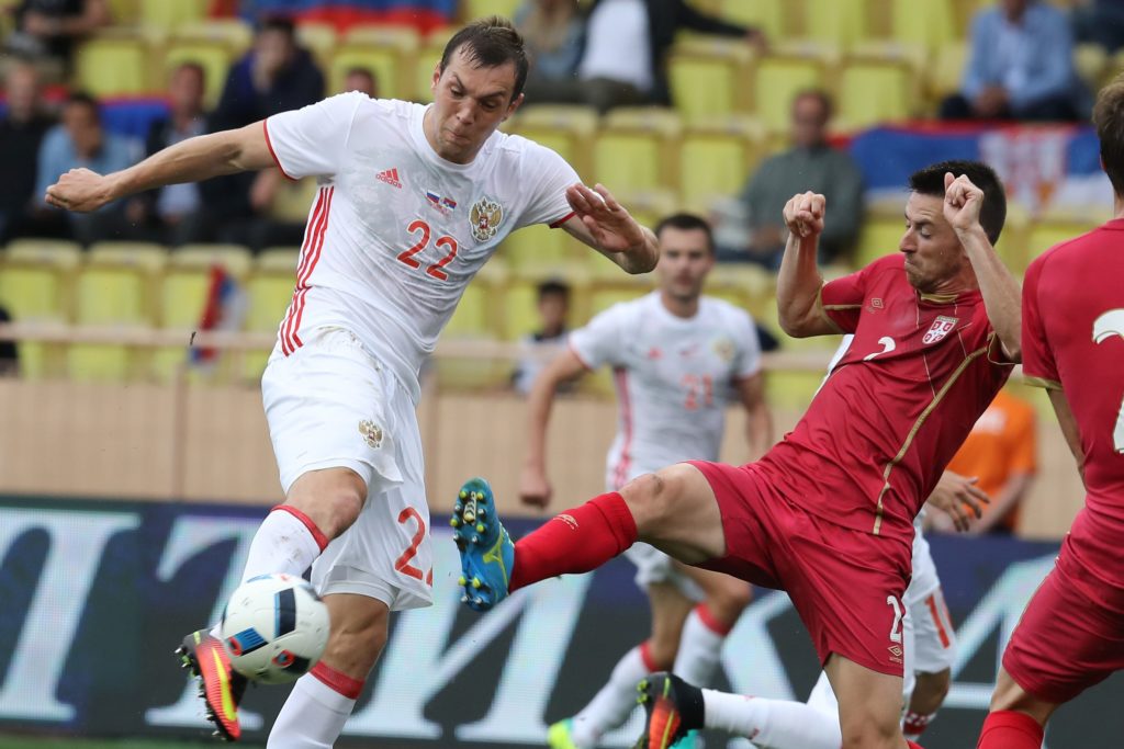Russia's Artem Dzyuba (L) vies with Serbia's Antonio Rukavina (R) during the friendly football match between Serbia and Russia on June 5, 2016 at the Louis II Stadium in Monaco. / AFP PHOTO / VALERY HACHE