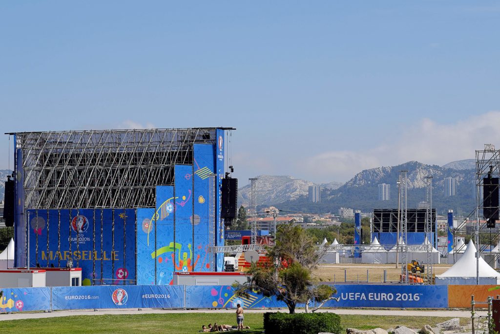 People lay down on the grass by the fan zone of Marseille on June 6, 2016, ahead of the UEFA EURO 2016 football championships, that takes place in France from June 10 until July 10, 2016. The French authorities have mustered 90,000 security personnel to guard stadiums and "fan zones" where spectators will gather to watch the matches on giant screens. / AFP PHOTO / BORIS HORVAT