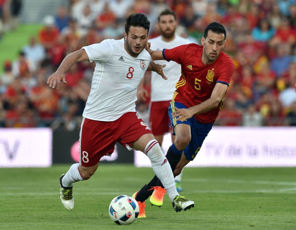 Georgia's midfielder Valeri Qazaishvili (L) vies for the ball with Spain's midfielder Sergio Busquets during the EURO 2016 friendly football match Spain vs Georgia at the Coliseum Alfonso Perez stadium in Getafe, on June 7, 2016, in preparation for the upcoming Euro 2016 European football championship. / AFP PHOTO / GERARD JULIEN