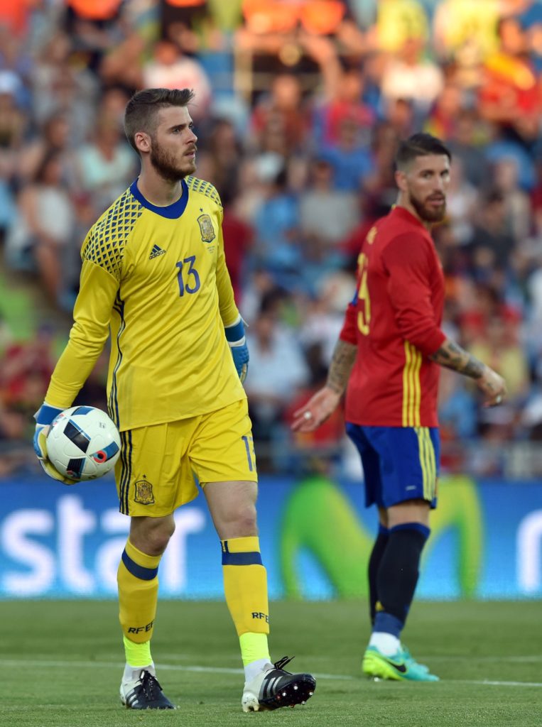 Spain's goalkeeper David de Gea (L) prepares to give the ball past Spain's defender Sergio Ramos during the EURO 2016 friendly football match Spain vs Georgia at the Coliseum Alfonso Perez stadium in Getafe, on June 7, 2016, in preparation for the upcoming Euro 2016 European football championship. / AFP PHOTO / GERARD JULIEN