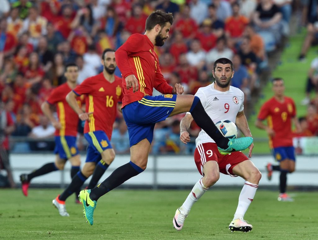 Spain's defender Gerard Pique (L) controls a ball past Georgia's forward Lado Dvalishvili during the EURO 2016 friendly football match Spain vs Georgia at the Coliseum Alfonso Perez stadium in Getafe, on June 7, 2016, in preparation for the upcoming Euro 2016 European football championship. / AFP PHOTO / GERARD JULIEN