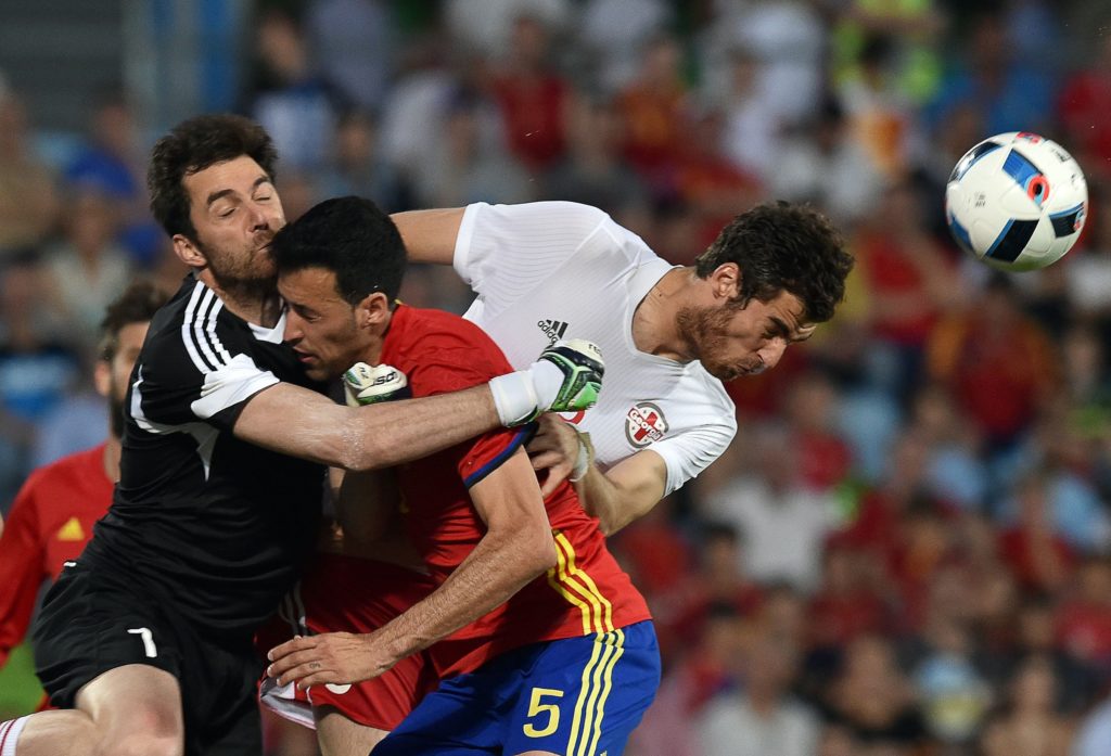 Georgia's goalkeeper Nukri Revishvili (L) collides Spain's midfielder Sergio Busquets (C) past Georgia's defender Solomon Kverkvelia during the EURO 2016 friendly football match Spain vs Georgia at the Coliseum Alfonso Perez stadium in Getafe, on June 7, 2016, in preparation for the upcoming Euro 2016 European football championship. / AFP PHOTO / GERARD JULIEN