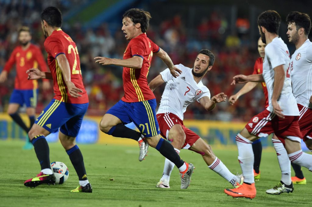 Spain's forward Silva (C) drives the ball past Georgia's midfielder Giorgi Aburjania during the EURO 2016 friendly football match Spain vs Georgia at the Coliseum Alfonso Perez stadium in Getafe, on June 7, 2016, in preparation for the upcoming Euro 2016 European football championship. / AFP PHOTO / GERARD JULIEN