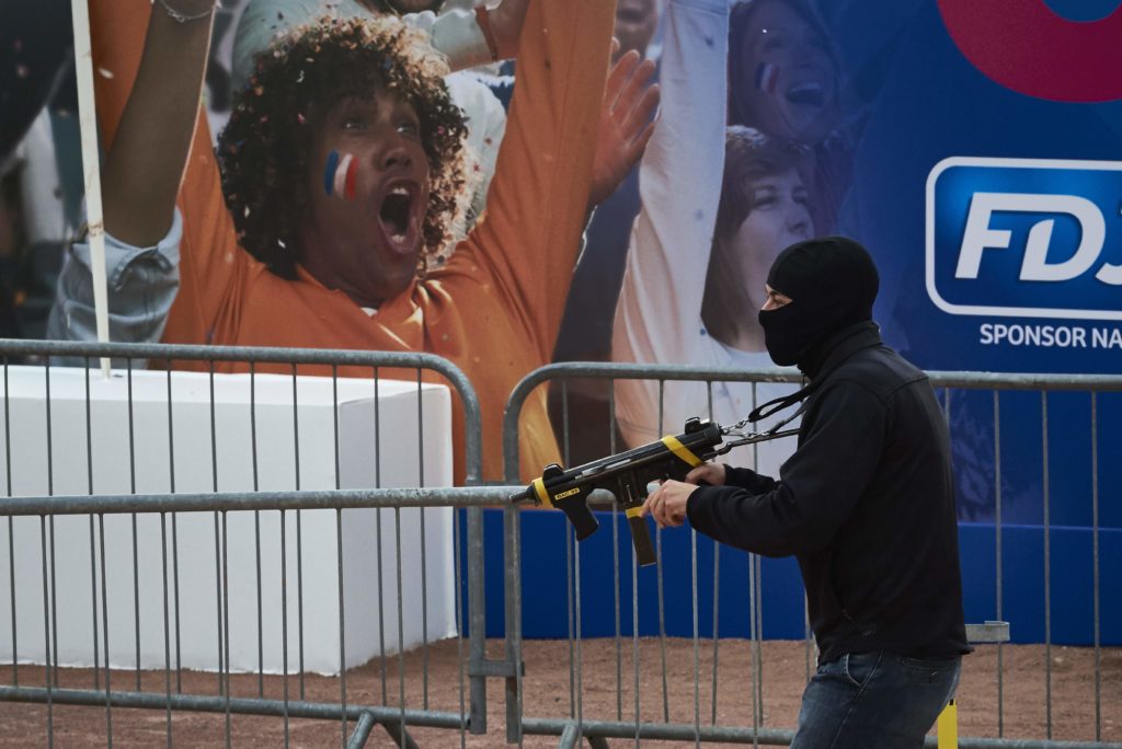 A man playing a terrorist fires at the crowd during a suicide attack exercise as part of security measures for the upcoming Euro 2016 football championship, at the fan zone in Lyon, central-eastern France, on June 7, 2016. / AFP PHOTO / JEAN-PHILIPPE KSIAZEK