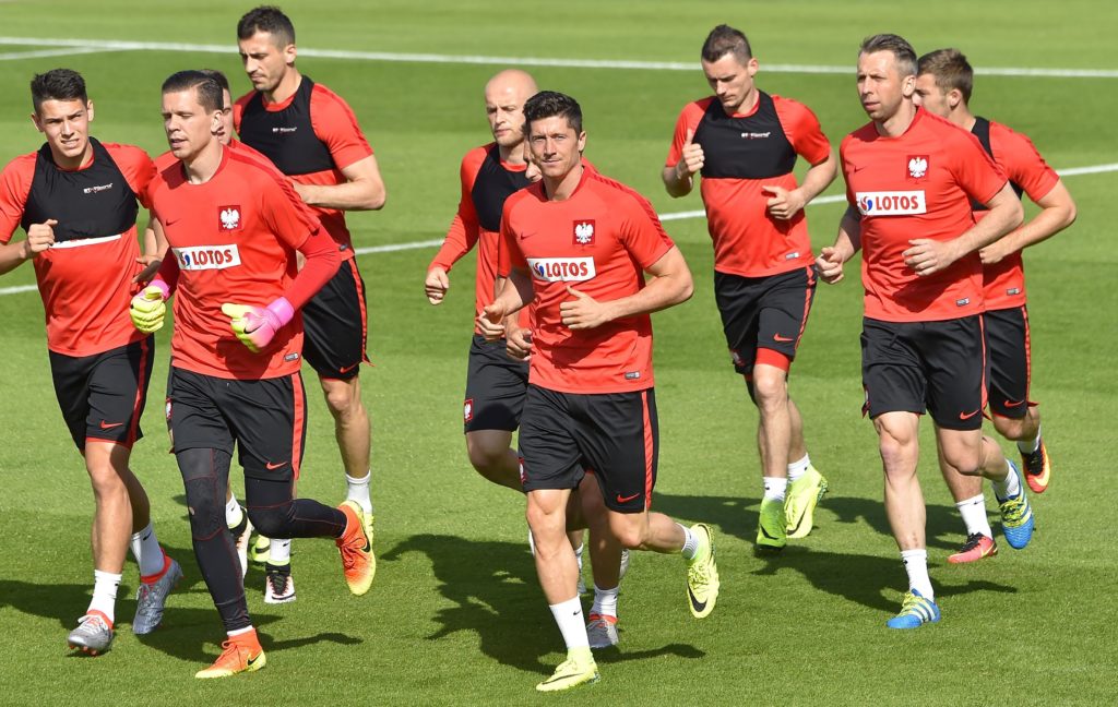 Poland's forward Robert Lewandowski (C) warms up with teammates during a training session at the team's training ground in La Baule, western France, on June 8, 2016, two days prior to the beginning of the Euro 2016 football tournament. / AFP PHOTO / LOIC VENANCE
