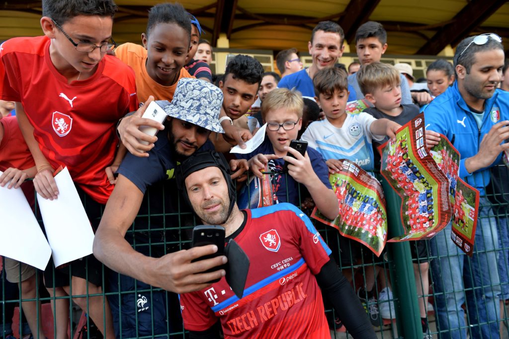 A fan takes a selfie photo with Czech Republic's goalkeeper Petr Cech (bottom) as others wait for an autograph after a training session of the national football team at their training ground in Tours ahead of the Euro 2016 football tournament, on June 8, 2016.  / AFP PHOTO / GUILLAUME SOUVANT