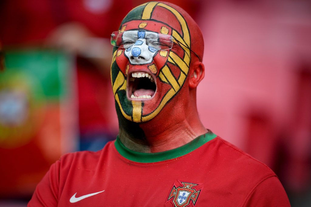 A supporter of Portugal's football team sings the national anthem before the friendly football match Portugal vs Estonia at Luz stadium in Lisbon on June 8, 2016, in preparation for the upcoming UEFA Euro 2016 Championship. / AFP PHOTO / PATRICIA DE MELO MOREIRA