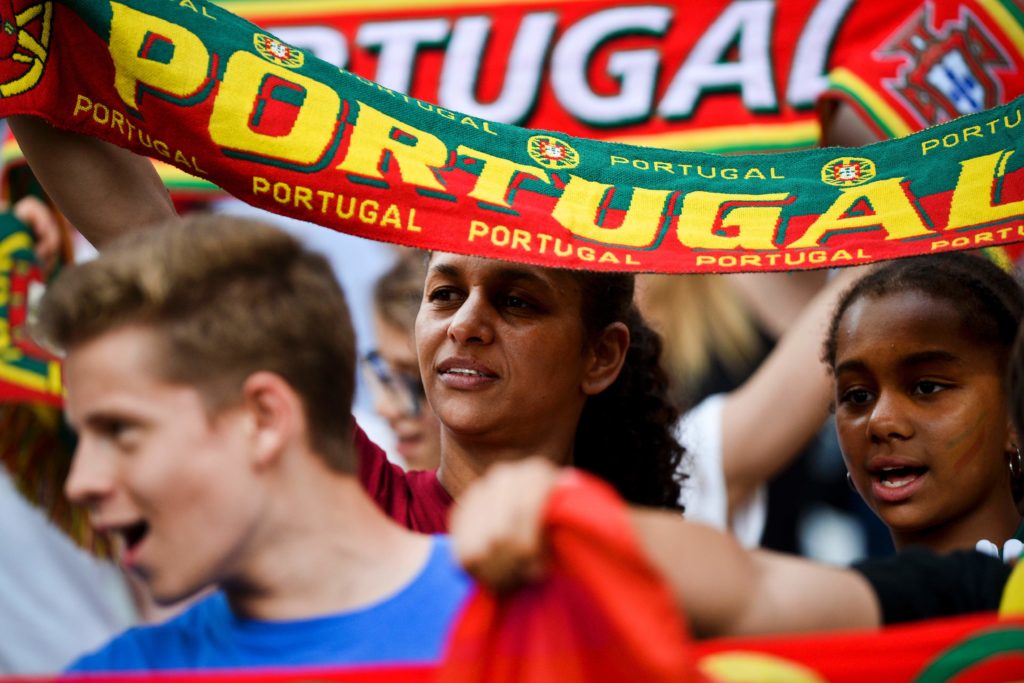 Supporters of Portugal's football team shout and hold scarves before the friendly football match Portugal vs Estonia at Luz stadium in Lisbon on June 8, 2016, in preparation for the upcoming UEFA Euro 2016 Championship. / AFP PHOTO / PATRICIA DE MELO MOREIRA