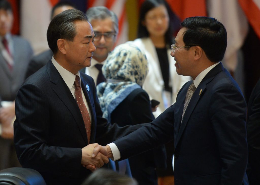 นายหวัง อี้ จับมือทักทาย นายฟาม บินห์ มินห์ (AFP)