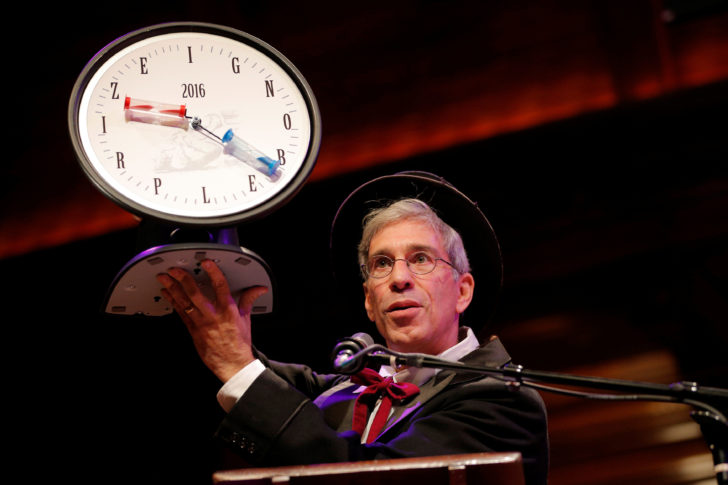 Master of Ceremonies Marc Abrahams holds up a 2016 Ig Nobel Prize while presiding over the 26th First Annual Ig Nobel Prize ceremony at Harvard University in Cambridge
