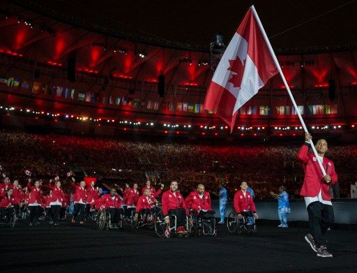 David Eng, representing Canada in Wheelchair Basketball, leads his fellow athletes into the arena during the Opening Ceremony of the Rio 2016 Paralympic Games at the Maracana Stadium in Rio de Janeiro, Brazil, on September 7, 2016. Photo by Al Tielemans/OIS/IOC via AFP. RESTRICTED TO EDITORIAL USE. / AFP PHOTO / OIS/IOC / Al Tielemans for OIS/IOC