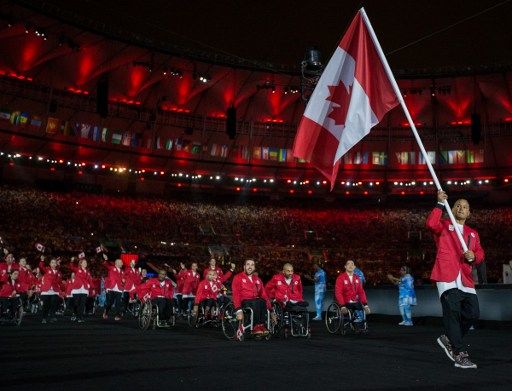 David Eng, representing Canada in Wheelchair Basketball, leads his fellow athletes into the arena during the Opening Ceremony of the Rio 2016 Paralympic Games at the Maracana Stadium in Rio de Janeiro, Brazil, on September 7, 2016. Photo by Al Tielemans/OIS/IOC via AFP. RESTRICTED TO EDITORIAL USE. / AFP PHOTO / OIS/IOC / Al Tielemans for OIS/IOC