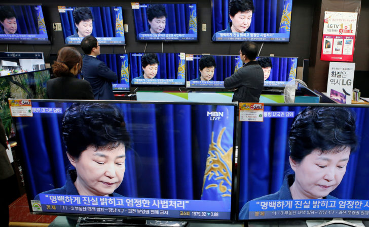 Employees watch TV sets broadcasting a news report on South Korean President Park Geun-hye releasing a statement to the public in Seoul