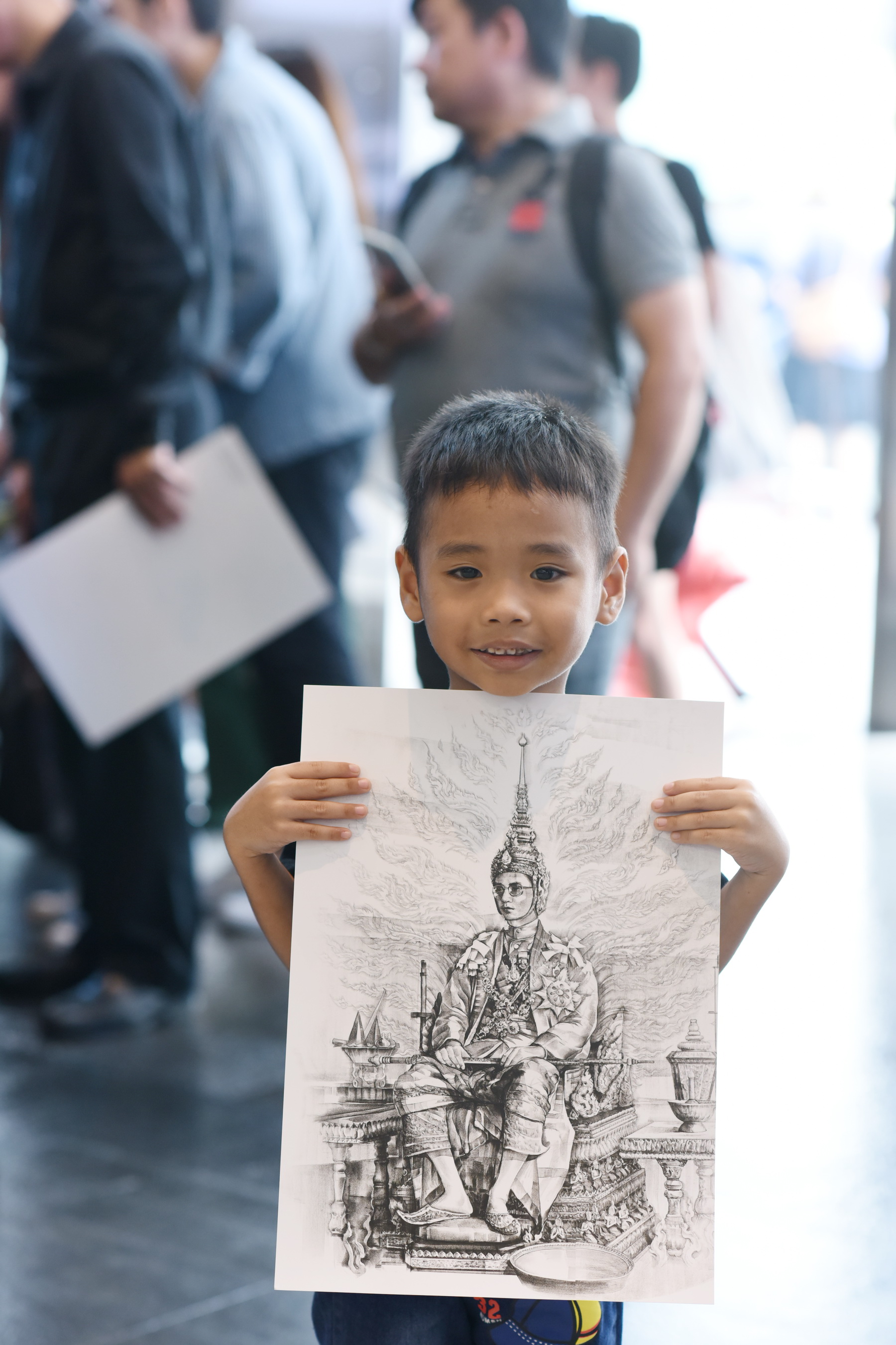เด็กน้อยมารอรับพระบรมสาทิสลักษ์พระบาทสมเด็จพระปรมินทรมหาภูมิพลอดุลยเดช จากฝีมืออ.สุวิทย์ ใจป้อม