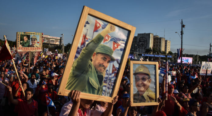 Cubans display pictures of Cuban former president Fidel Castro and president Raul Castro (R) during the May Day parade in Havana, on May 1, 2016. / AFP PHOTO / ADALBERTO ROQUE