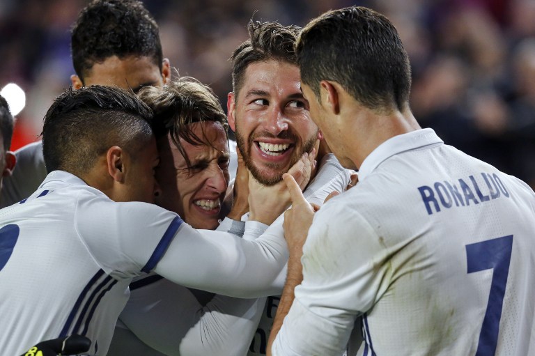 Real Madrid's defender Sergio Ramos (2ndR) celebrates with Real Madrid's Croatian midfielder Luka Modric (2ndL) and teammates after scoring the equalizer during the Spanish league football match FC Barcelona vs Real Madrid CF at the Camp Nou stadium in Barcelona on December 3, 2016. / AFP PHOTO / PAU BARRENA