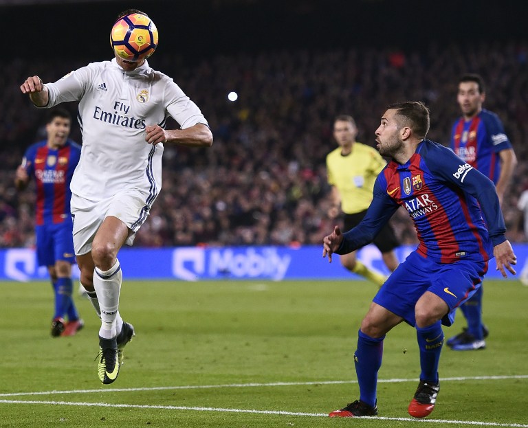 Barcelona's defender Jordi Alba (R) looks at Real Madrid's Portuguese forward Cristiano Ronaldo during the Spanish league football match FC Barcelona vs Real Madrid CF at the Camp Nou stadium in Barcelona on December 3, 2016. / AFP PHOTO / JOSEP LAGO