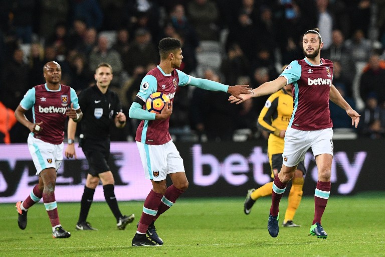 West Ham United's English striker Andy Carroll (R) celebrates with West Ham United's English striker Ashley Fletcher after scoring their first goal during the English Premier League football match between West Ham United and Arsenal at The London Stadium, in east London on December 3, 2016. Arsenal won the game 5-1. / AFP PHOTO / Justin TALLIS / RESTRICTED TO EDITORIAL USE. No use with unauthorized audio, video, data, fixture lists, club/league logos or 'live' services. Online in-match use limited to 75 images, no video emulation. No use in betting, games or single club/league/player publications. /