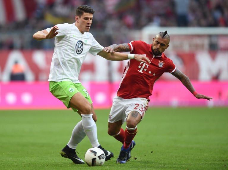Wolfsburg's forward Mario Gomez (L) and Bayern Munich's Chilean midfielder Arturo Vidal vie for the ball during the German first division Bundesliga football match between FC Bayern Munich and Wolfsburg in Munich, southern Germany, on December 10, 2016. / AFP PHOTO / CHRISTOF STACHE / RESTRICTIONS: DURING MATCH TIME: DFL RULES TO LIMIT THE ONLINE USAGE TO 15 PICTURES PER MATCH AND FORBID IMAGE SEQUENCES TO SIMULATE VIDEO. == RESTRICTED TO EDITORIAL USE == FOR FURTHER QUERIES PLEASE CONTACT DFL DIRECTLY AT + 49 69 650050
