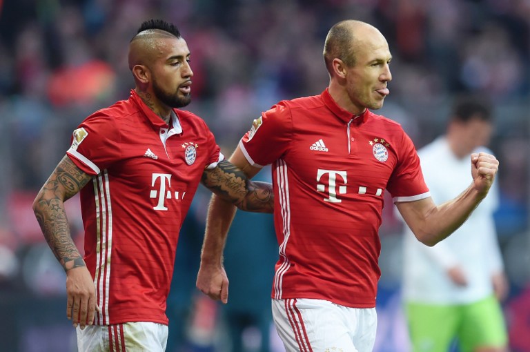 Bayern Munich's Chilian midfielder Arturo Vidal (L) and Bayern Munich's Dutch midfielder Arjen Robben (R) celebrate after Robben scored the first goal during the German first division Bundesliga football match between FC Bayern Munich and Wolfsburg in Munich, southern Germany, on December 10, 2016. / AFP PHOTO / CHRISTOF STACHE / RESTRICTIONS: DURING MATCH TIME: DFL RULES TO LIMIT THE ONLINE USAGE TO 15 PICTURES PER MATCH AND FORBID IMAGE SEQUENCES TO SIMULATE VIDEO. == RESTRICTED TO EDITORIAL USE == FOR FURTHER QUERIES PLEASE CONTACT DFL DIRECTLY AT + 49 69 650050