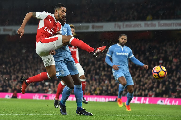Arsenal's English midfielder Theo Walcott (L) shoots and scores past Stoke City's Portuguese-born Dutch defender Bruno Martins Indi during the English Premier League football match between Arsenal and Stoke City at the Emirates Stadium in London on December 10, 2016. / AFP PHOTO / Glyn KIRK / RESTRICTED TO EDITORIAL USE. No use with unauthorized audio, video, data, fixture lists, club/league logos or 'live' services. Online in-match use limited to 75 images, no video emulation. No use in betting, games or single club/league/player publications. /
