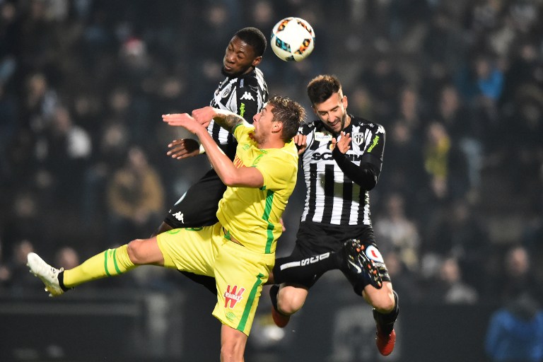 Nantes' Icelandic forward Kolbeinn Sigthorsson (C) heads the ball with Angers' Cameroonian forward Karl Toko Ekambi (back) and Angers' French defender Pablo Martinez (R) during the French L1 football match between Angers and Nantes at the Jean Bouin Stadium in Angers, northwestern France, on December 16, 2016. / AFP PHOTO / JEAN-FRANCOIS MONIER