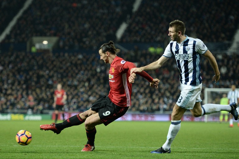 Manchester United's Swedish striker Zlatan Ibrahimovic (L) shoots to score their second goal during the English Premier League football match between West Bromwich Albion and Manchester United at The Hawthorns stadium in West Bromwich, central England, on December 17, 2016. / AFP PHOTO / Oli SCARFF / RESTRICTED TO EDITORIAL USE. No use with unauthorized audio, video, data, fixture lists, club/league logos or 'live' services. Online in-match use limited to 75 images, no video emulation. No use in betting, games or single club/league/player publications. /