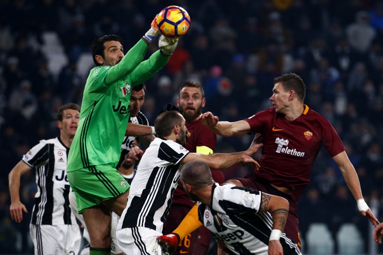 Juventus' goalkeeper Gianluigi Buffon (up) tries to catch the ball during the Italian Serie A football match Juventus vs As Roma on December 17, 2016 at the 'Juventus Stadium' in Turin. / AFP PHOTO / MARCO BERTORELLO