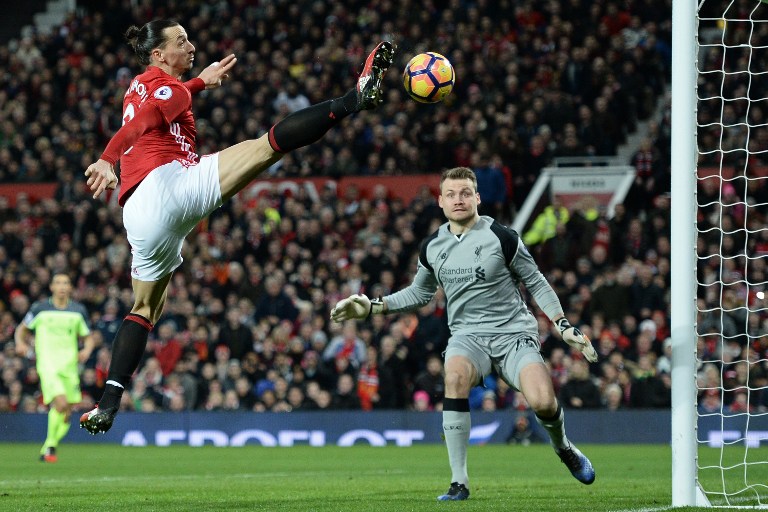 Manchester United's Swedish striker Zlatan Ibrahimovic (L) jumps for the ball but fails to score during the English Premier League football match between Manchester United and Liverpool at Old Trafford in Manchester, north west England, on January 15, 2017. / AFP PHOTO / Oli SCARFF / RESTRICTED TO EDITORIAL USE. No use with unauthorized audio, video, data, fixture lists, club/league logos or 'live' services. Online in-match use limited to 75 images, no video emulation. No use in betting, games or single club/league/player publications. /