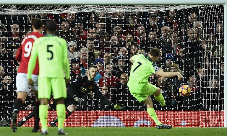 Liverpool's English midfielder James Milner (R) shoots from the penalty spot to score his team's first goal past Manchester United's Spanish goalkeeper David de Gea (C) during the English Premier League football match between Manchester United and Liverpool at Old Trafford in Manchester, north west England, on January 15, 2017. / AFP PHOTO / Oli SCARFF / RESTRICTED TO EDITORIAL USE. No use with unauthorized audio, video, data, fixture lists, club/league logos or 'live' services. Online in-match use limited to 75 images, no video emulation. No use in betting, games or single club/league/player publications. /
