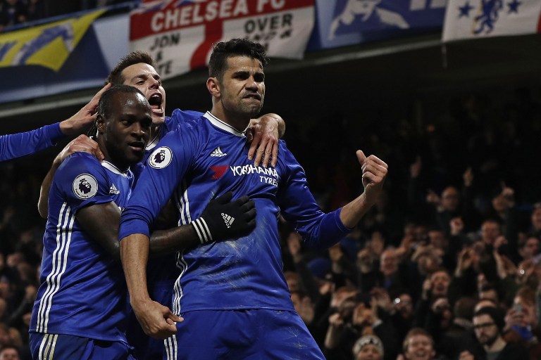 Chelsea's Brazilian-born Spanish striker Diego Costa (R) celebrates with teammates after scoring the opening goal of the English Premier League football match between Chelsea and Hull City at Stamford Bridge in London on January 22, 2017. / AFP PHOTO / Adrian DENNIS / RESTRICTED TO EDITORIAL USE. No use with unauthorized audio, video, data, fixture lists, club/league logos or 'live' services. Online in-match use limited to 75 images, no video emulation. No use in betting, games or single club/league/player publications. /