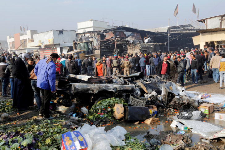 People gather at the site of a car bomb attack at a vegetable market in eastern Baghdad