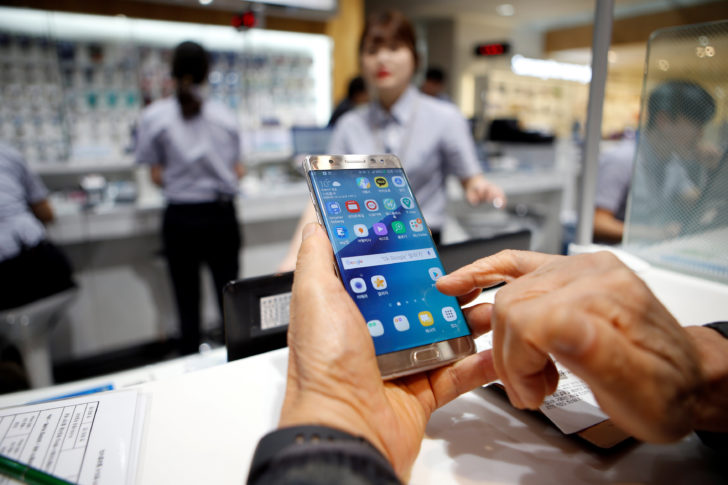 FILE PHOTO - A customer uses his Samsung Electronics' Galaxy Note 7 as he waits for exchange at company's headquarters in Seoul