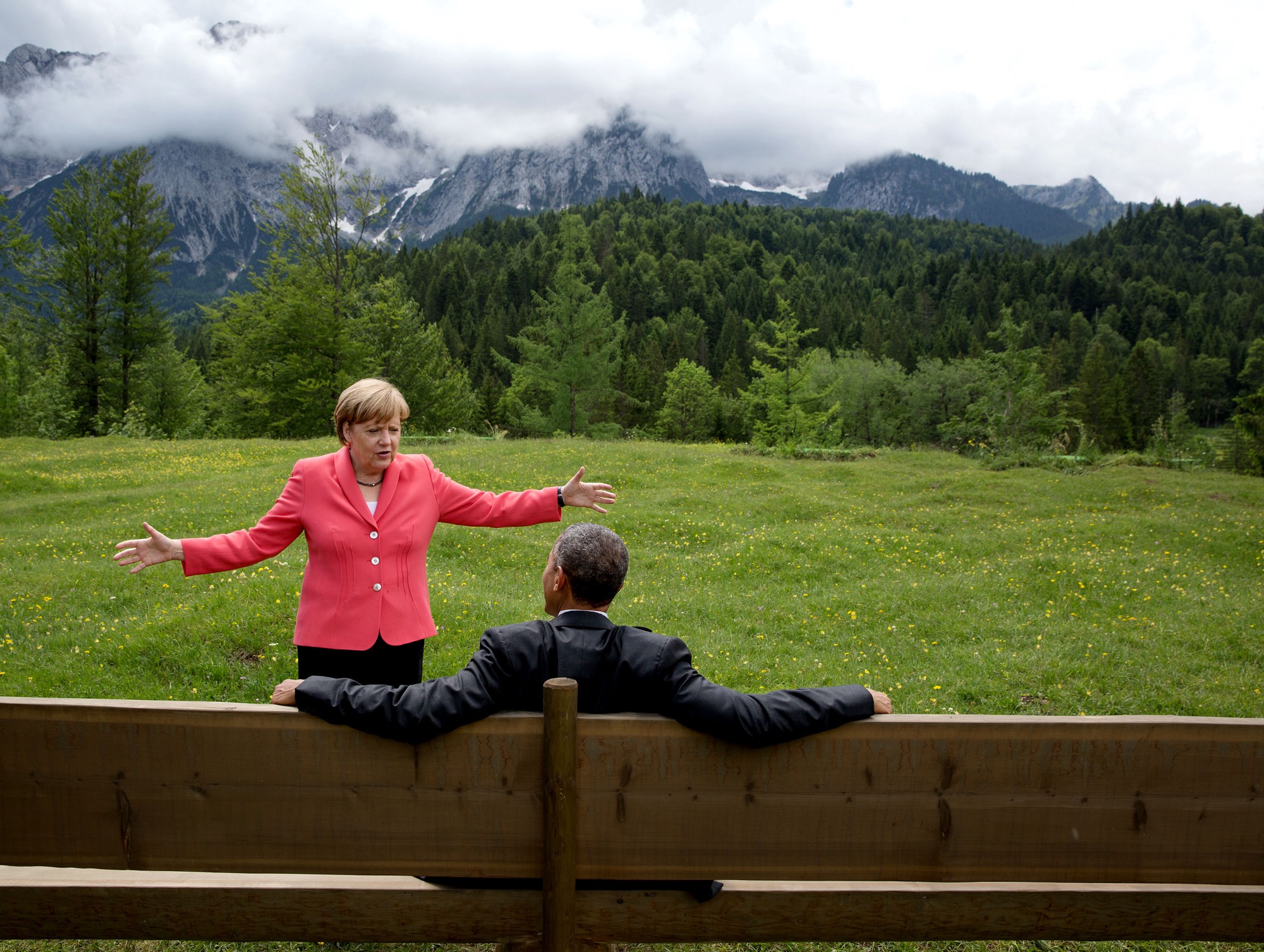 โอบามาสนทนากับอังเกลา แมร์เคิล นายกรัฐมนตรีเยอรมนี ขณะรอผู้นำชาติอื่นๆ ก่อนหน้าการถ่ายภาพหมู่ในการประชุมสุดยอดผู้นำ จี7 ที่เมืองครูน ประเทศเยอรมนีเมื่อ 8 มิถุนายน 2558 / Official White House Photo by Pete Souza 