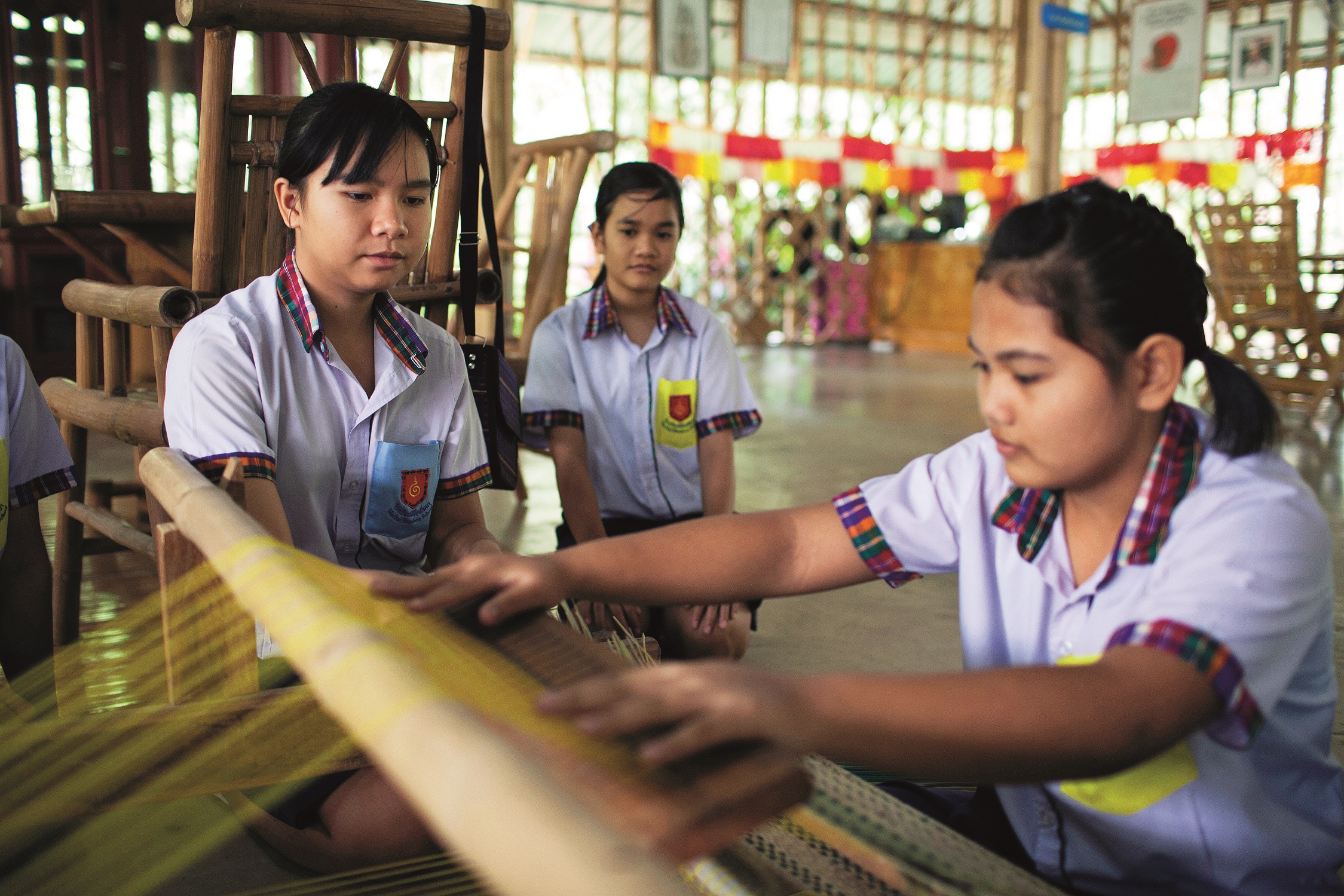 Students weave a silk product at the Bamboo School, in Lam Plai Mat district, Thailand, November 7, 2013. Photo by Will Baxter/for The Wall Street Journal